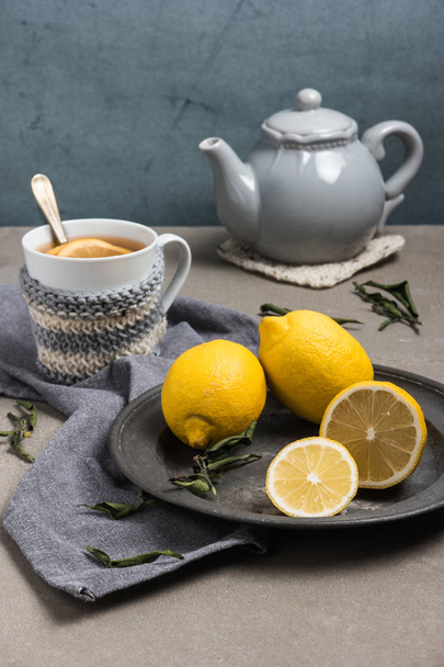 Cup of tea with lemon on table close-up. Healthcare traditional medicine and flu concept - tea cup with lemon. Hot tea with lemon treatment of colds flu and runny. - Φωτογραφία, εικόνα