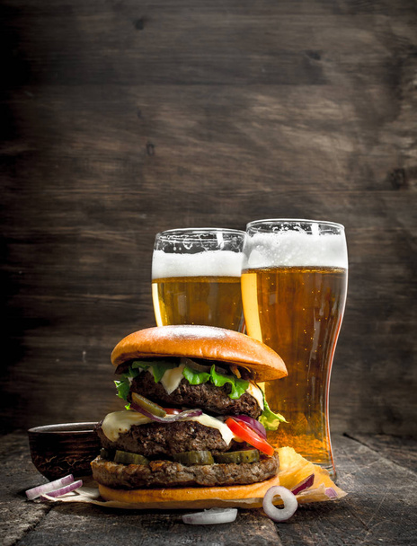 Street food. A big burger with glasses of light beer. - Foto, imagen