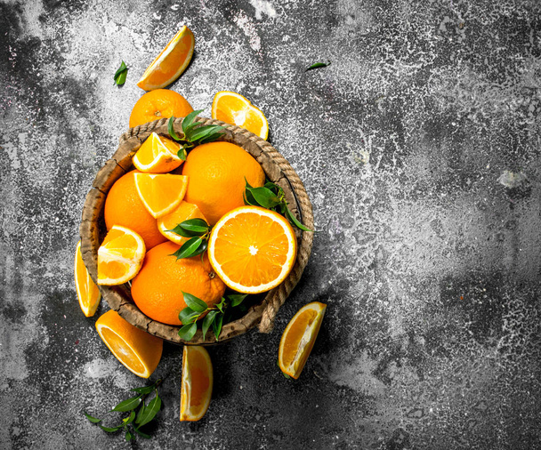 Fresh oranges in a wooden bucket. - Foto, immagini