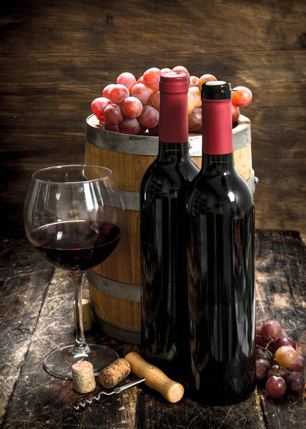 Wine background. A barrel with red wine and freshly grapes. - Fotoğraf, Görsel
