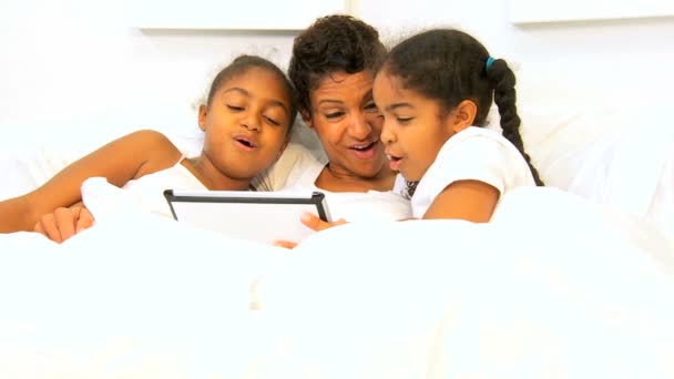 Africano americano mamá niñas cama inalámbrico tableta
 - Imágenes, Vídeo