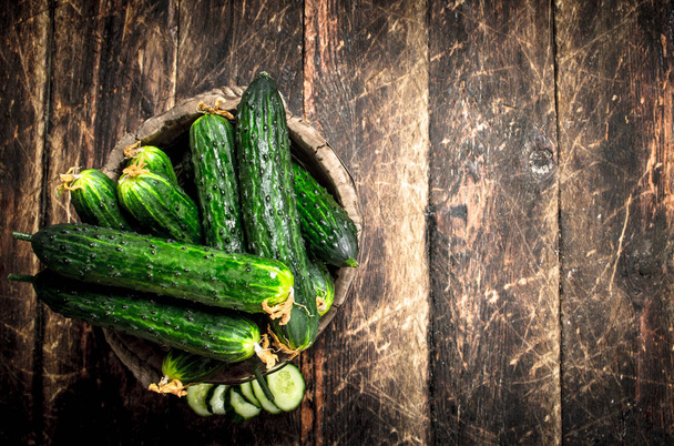 Cucumbers in a wooden bucket. - Foto, Bild