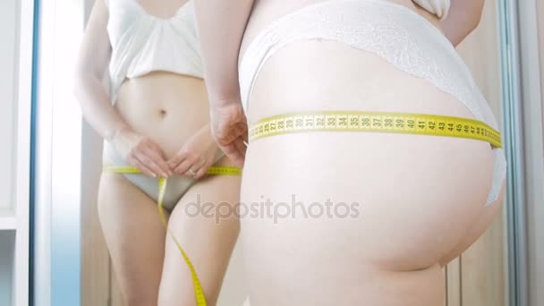 4 k videa sexy žena v bílé krajkové prádlo měření její boky a stehna na zrcadlo - Záběry, video