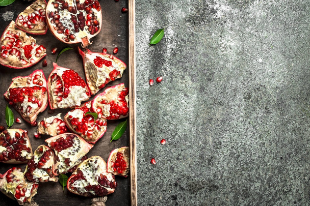 Fresh pomegranates on a wooden tray. - Фото, зображення