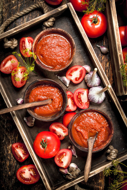 Tomato sauce with spices and garlic in the old tray. - Photo, Image
