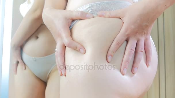 Closeup 4k görüntüleri genç kadının vücudu ayna, selülit için inceliyor - Video, Çekim