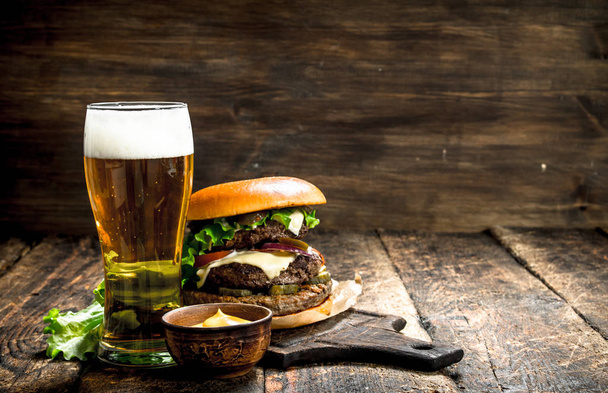 Fast food. A big burger with beef and a glass of beer. - Foto, immagini