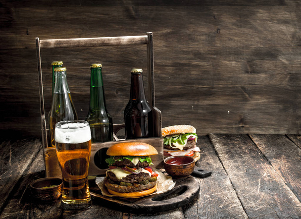 Street food. Fresh burgers with a box of beer. - 写真・画像