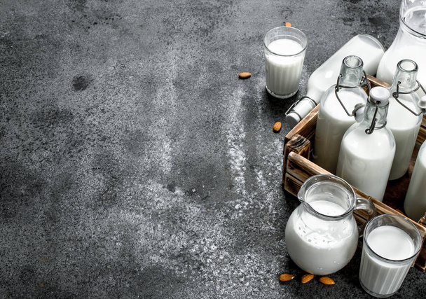 Fresh milk in bottles and jugs with a wooden box. - Фото, зображення