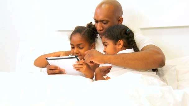 Giovane etnico singolo padre bambini utilizzando senza fili Tablet Bed
 - Filmati, video