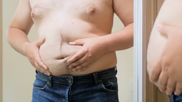 4 k beelden van overgewicht permanent op spiegel en voorwenden om fit en gespierde man - Video