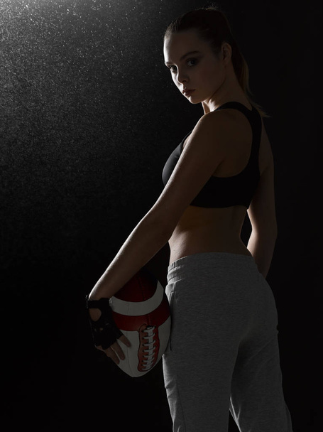 A girl in a sports suit is standing with a ball. - Foto, imagen