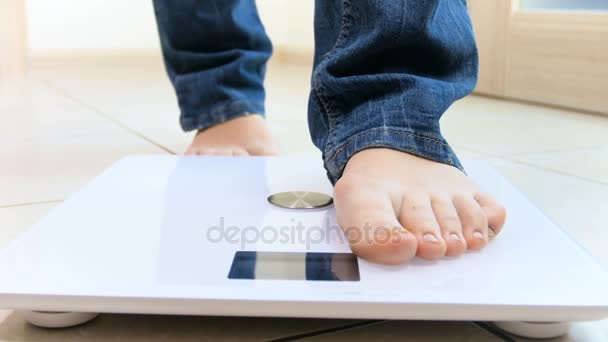 4k video of young woman checking her weight on electronic scales - Footage, Video