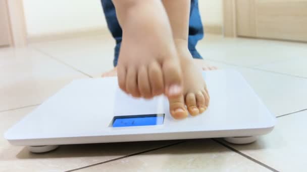 4k closeup video of baby and mothers feet standing on weight scales - Footage, Video