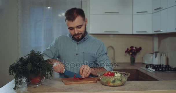 Νεαρός άνδρας Ετοιμάστε τα λαχανικά να κάνει τα τρόφιμα στην κουζίνα, χορός - Πλάνα, βίντεο