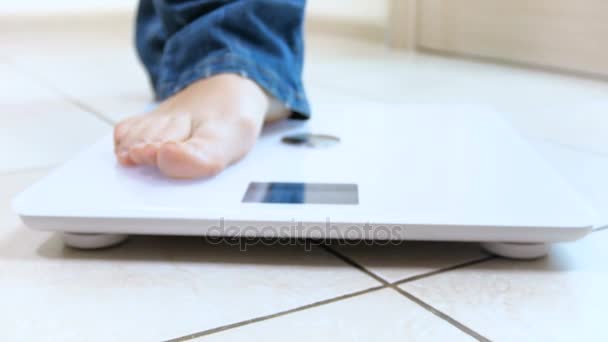 4k dolly vídeo of young woman stepping on electronic weight scales
 - Filmagem, Vídeo