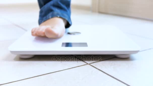 Lähikuva nukke laukaus nuori nainen seisoo ja mitata hänen painonsa asteikolla
 - Materiaali, video