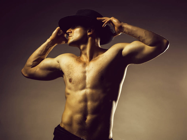 Сексуальна м'язиста людина в капелюсі
 - Фото, зображення