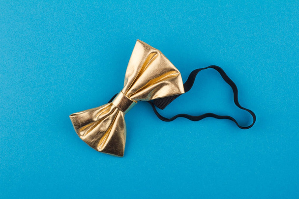 golden bow tie on blue background - Photo, Image
