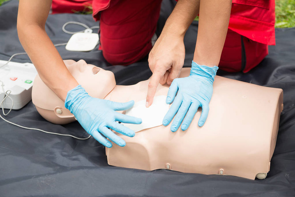 Практика CPR женщины и мужчины на манекенах CPR на открытом воздухе
 - Фото, изображение