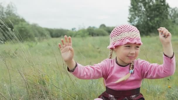mała dziewczynka gra na polu - Materiał filmowy, wideo