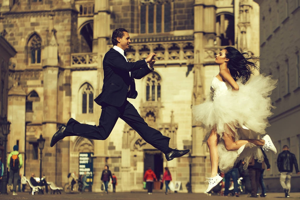 wedding happy couple jumping near castle - Foto, afbeelding