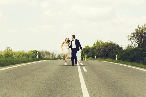 wedding happy couple running on road - Zdjęcie, obraz