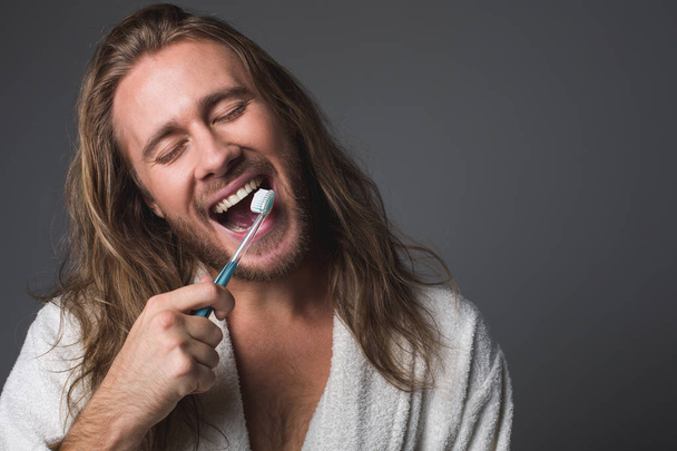 Positive male taking care about teeth - Zdjęcie, obraz