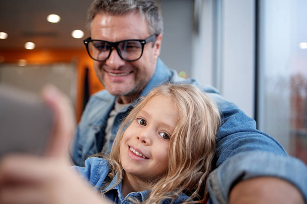 Positive middle-aged man and child are taking selfie - Fotoğraf, Görsel
