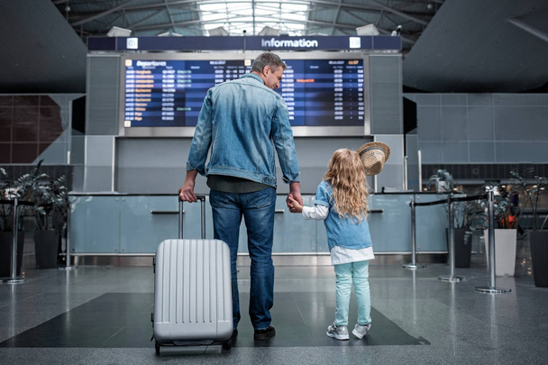 空港で子供とうれしそうな男が立っています。 - 写真・画像