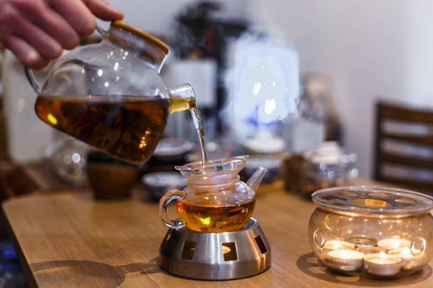 Blooming flower Tea is poured from a teapot into a cup.  - Valokuva, kuva