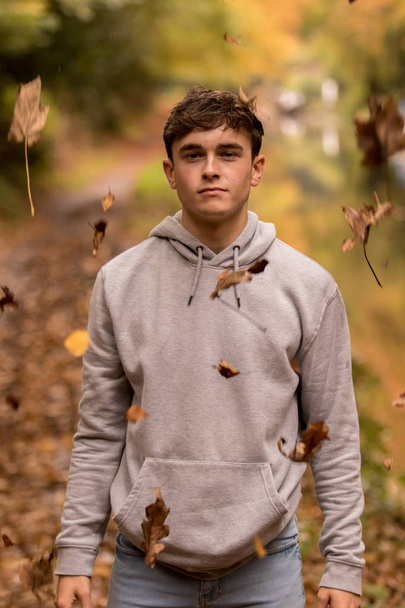 Teenage boy and falling leaves - Фото, изображение
