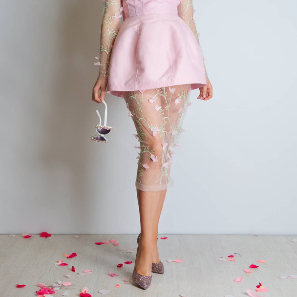 Perfect slim long female legs and pink dress - Foto, Imagen