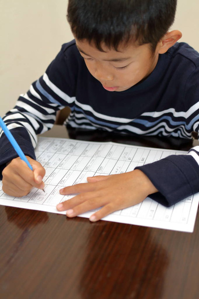 Ιαπωνικό αγόρι κάνει την εργασία (δεύτερου βαθμού στο Δημοτικό σχολείο) - Φωτογραφία, εικόνα