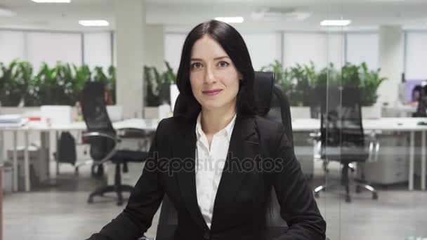 Erwachsene Geschäftsfrau lächelt am Arbeitsplatz im Büro - Filmmaterial, Video