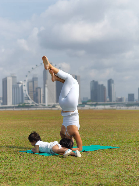 Asijská Čínská žena cvičení jógy venku s mladými holčičku - Fotografie, Obrázek