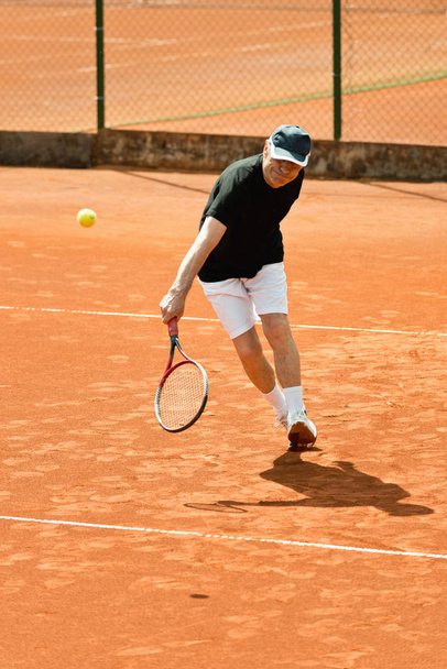 Jogador do sexo masculino sênior batendo bola
 - Foto, Imagem