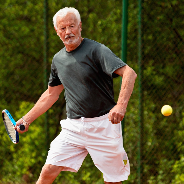 Jugador de tenis senior jugando tenis
 - Foto, imagen