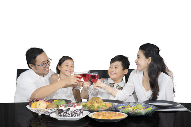 Iloinen perhe on paahtolasit ennen aterioita
 - Valokuva, kuva