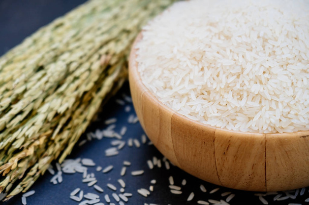 Ham Yasemin pirinç ahşap kase ve kaşık ile tahıl ve tohum - Fotoğraf, Görsel