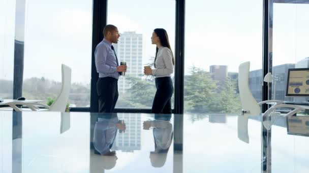 4 k Business man en vrouw met koffie chatten voor grote kantoor raam. - Video