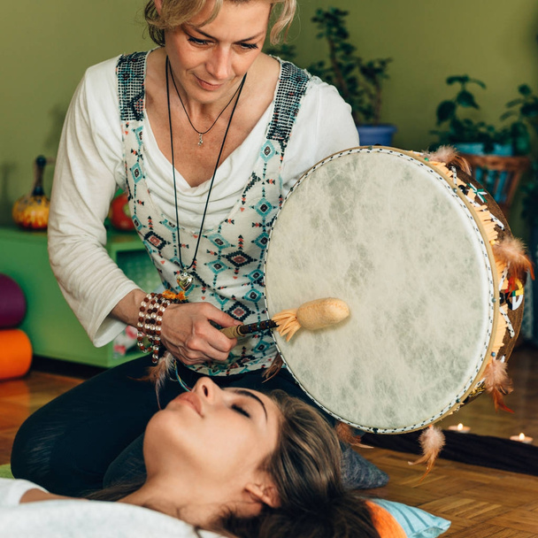 mulher usando tambor indiano em terapia de som
 - Foto, Imagem