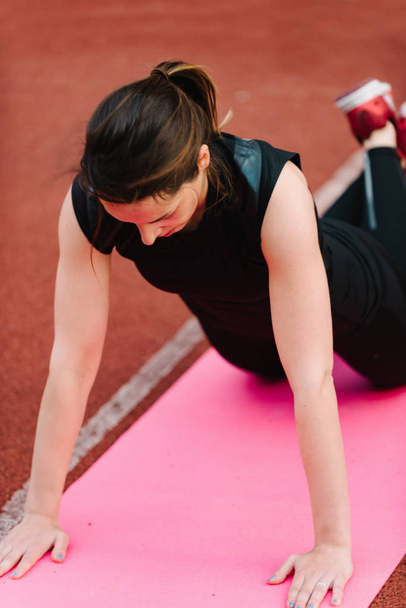 Jeune femme faisant push ups sur la concurrence à l'extérieur
 - Photo, image