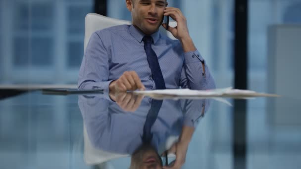 4K Cheerful businessman talking on phone at his desk in modern office - Felvétel, videó