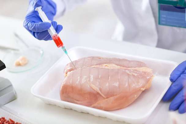 Putting sample of chemical with injection in to the test chicken - Photo, Image