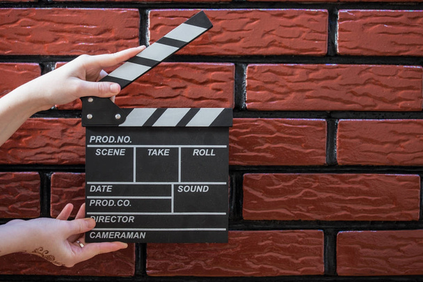 Κλακέτα πλάκες, γυναικεία χέρια και μια κλακέτα ταινία με ένα τούβλο β - Φωτογραφία, εικόνα