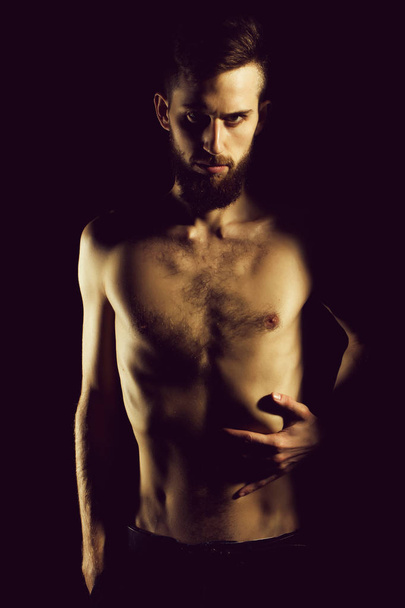 slim bearded man with thin bare torso isolated on black - Fotó, kép