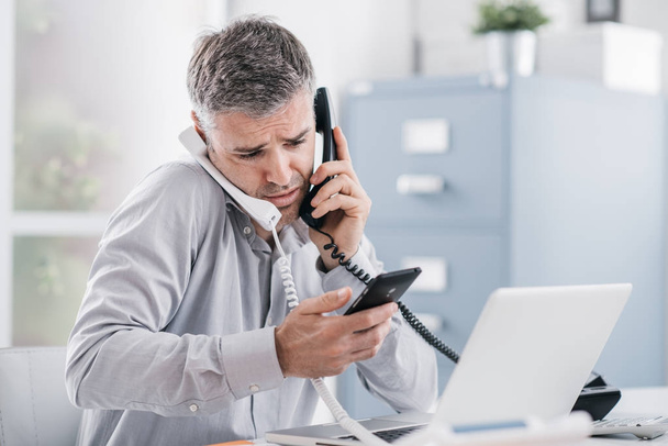 Stressed businessman having multiple calls - Foto, Imagem