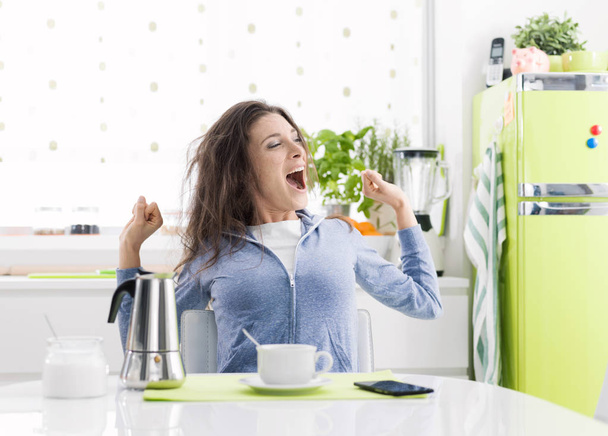 Tired woman having breakfast at home - Foto, imagen