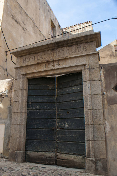Corsica, 03 / 09 / 2017: il cartello sulla porta di accesso dell'antico ospedale militare, costruito nel 1844 nella arroccata e antica Cittadella di Calvi, famosa meta turistica sulla costa nord-occidentale
 - Foto, immagini